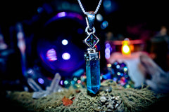 Crystal pendant on a mystical background with candles and crystals 7 ARCHANGEL GENIES Djinn Amulet