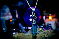 7 ARCHANGEL GENIES Djinn Amulet Blue crystal pendant necklace on a dark background with blurred lights