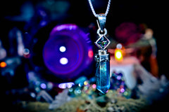 7 ARCHANGEL GENIES Djinn Amulet Crystal pendant necklace with a blurred colorful background