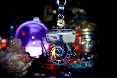 Necklace with a pendant featuring a crystal and decorative elements against a dark background.
