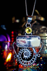 Spell Necklace with a unique pendant featuring a yellow gemstone and intricate design against a dark background.