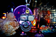Spell Necklace with a mechanical design pendant on a dark background with crystals and lights.