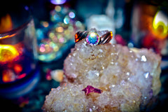 Ring with a colorful gemstone on a crystal rock with a blurred multicolored background