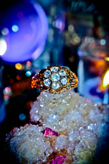 Gold ring with gemstones on a crystal surface with a blurred colorful background
