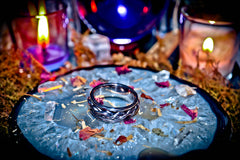 Crystal ball with rings and candles on a mystical table setting